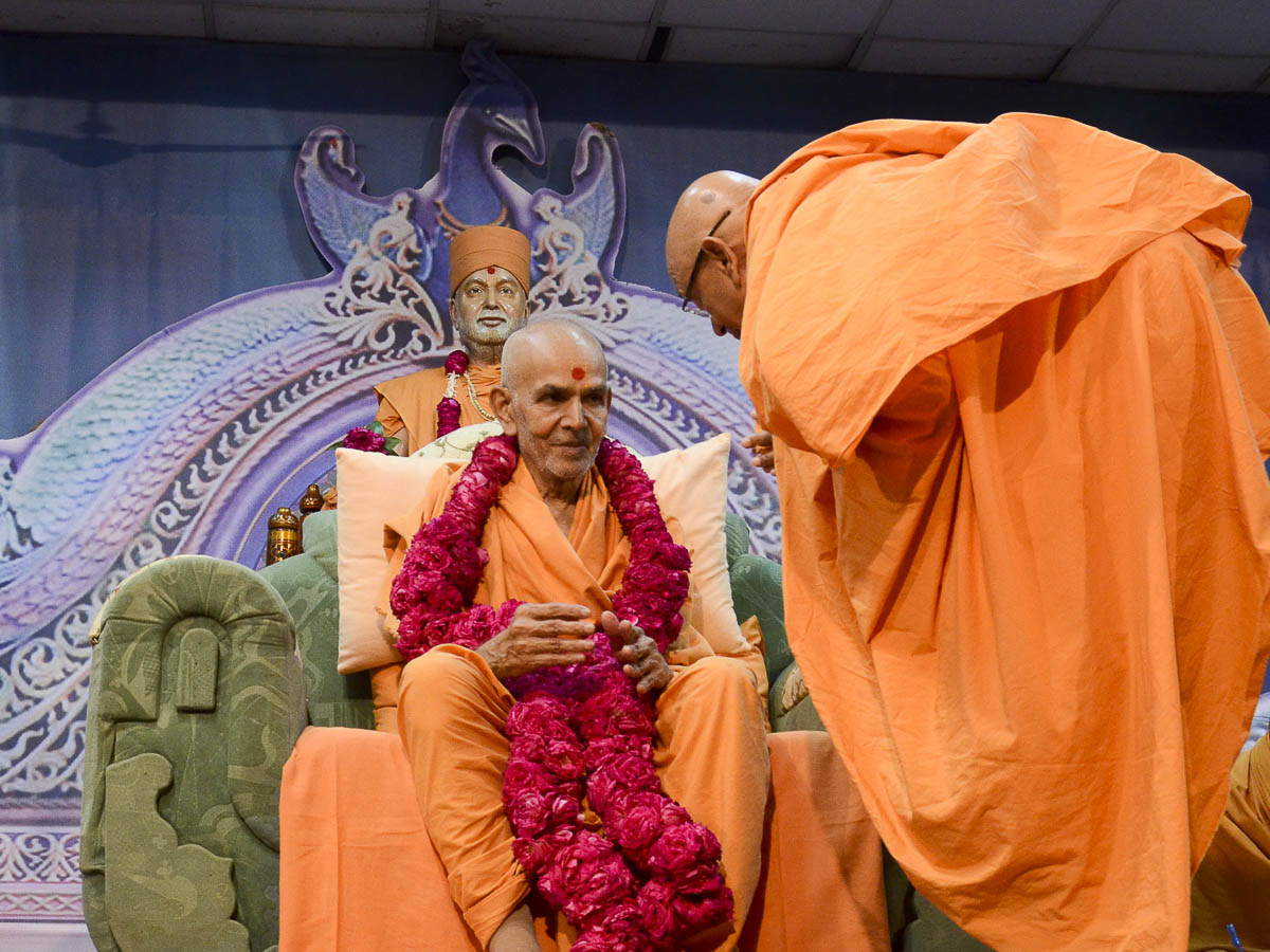 Pujya Tyagvallabh Swami honors Param Pujya Mahant Swami with a garland, 24 Aug 2016