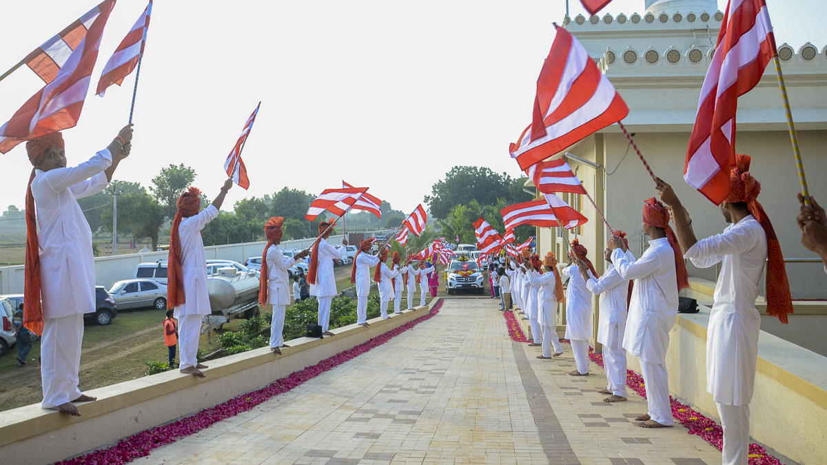 Youths welcome Param Pujya Mahant Swami to the assembly with BAPS flags