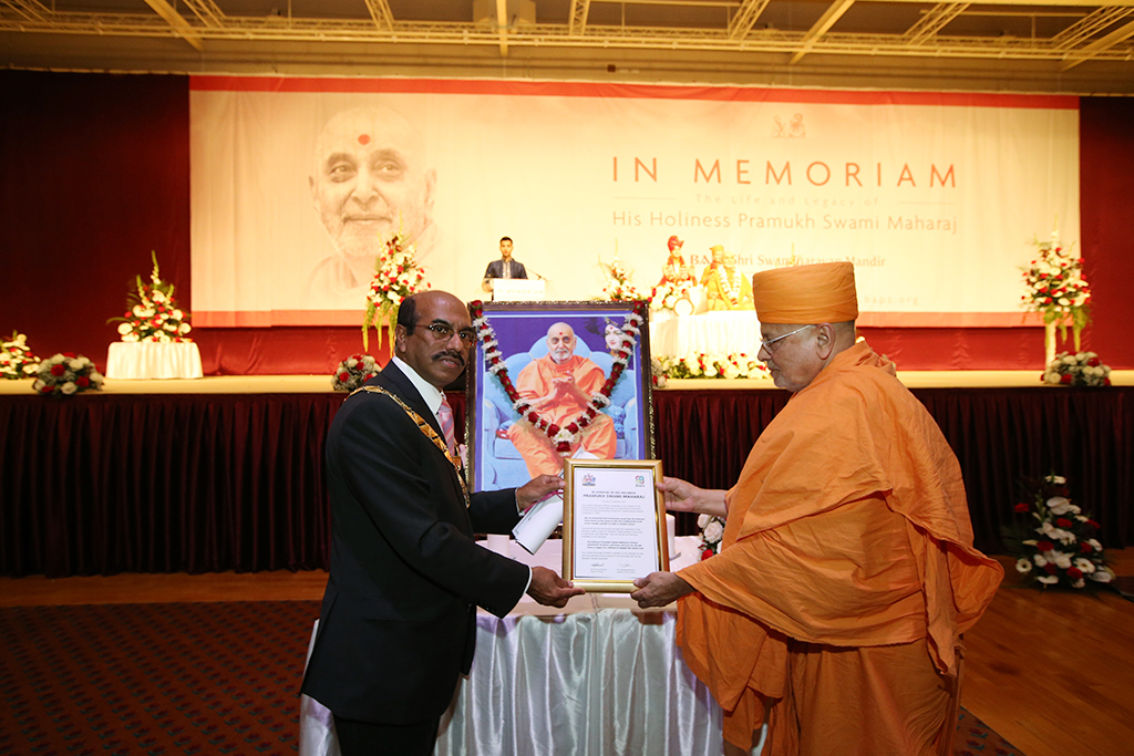 Mayor of Brent, Cllr Parvez Ahmed, presents certificate in honour of HH Pramukh Swami Maharaj on behalf of Brent Council to Pujya Ishwarcharan Swami