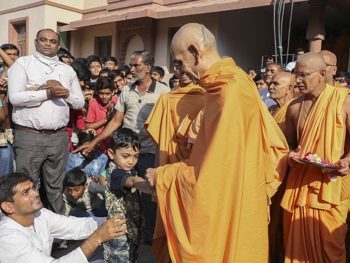 Param Pujya Mahant Swami ties nadachhadi on a child's wrist, 16 Oct 2016