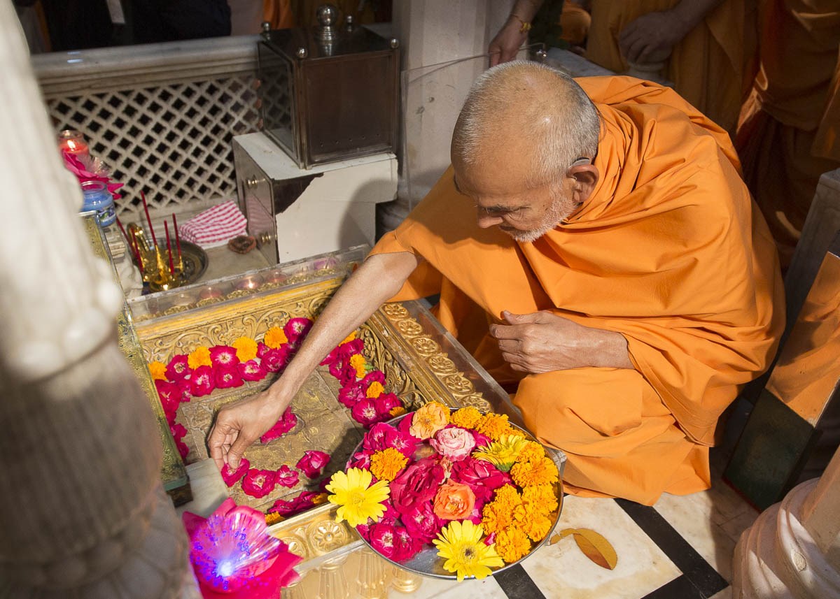Param Pujya Mahant Swami arranges flowers at the Akshar Deri