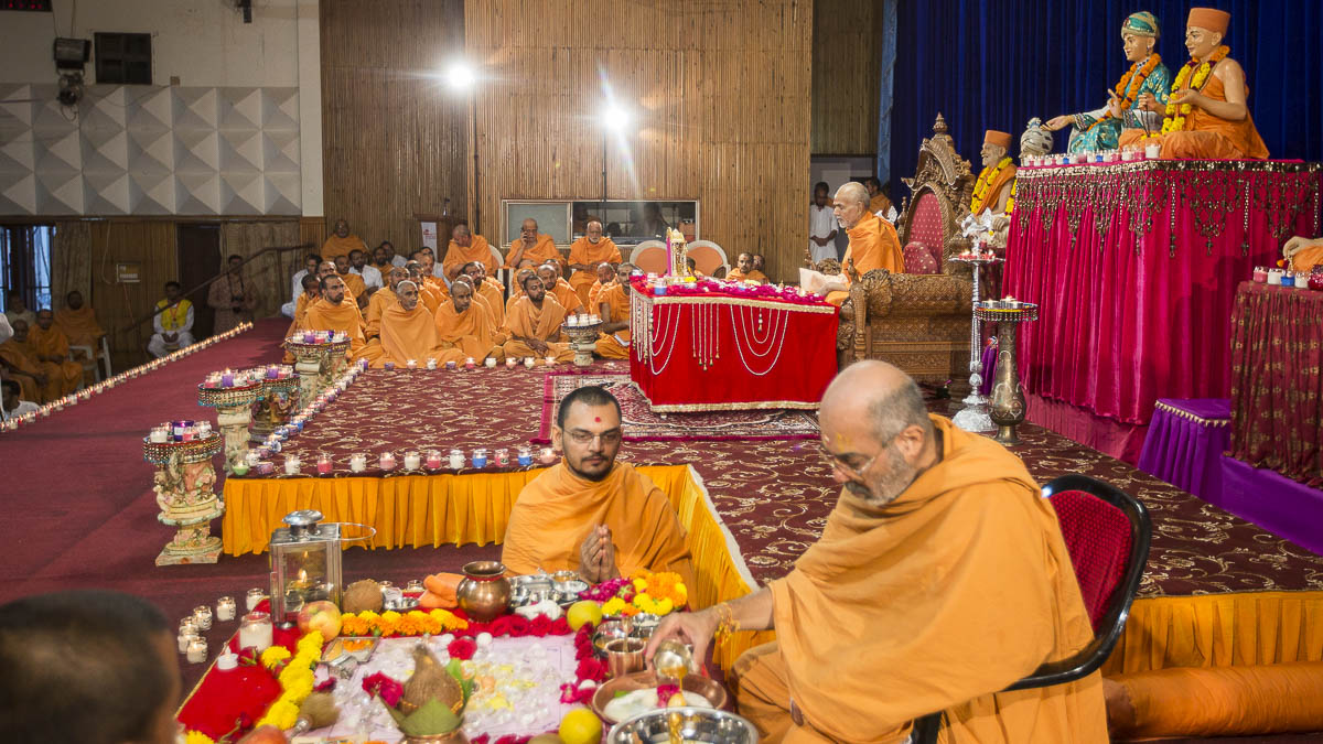 Param Pujya Mahant Swami performs his morning puja and Dharmacharan Swami performs New Year mahapuja