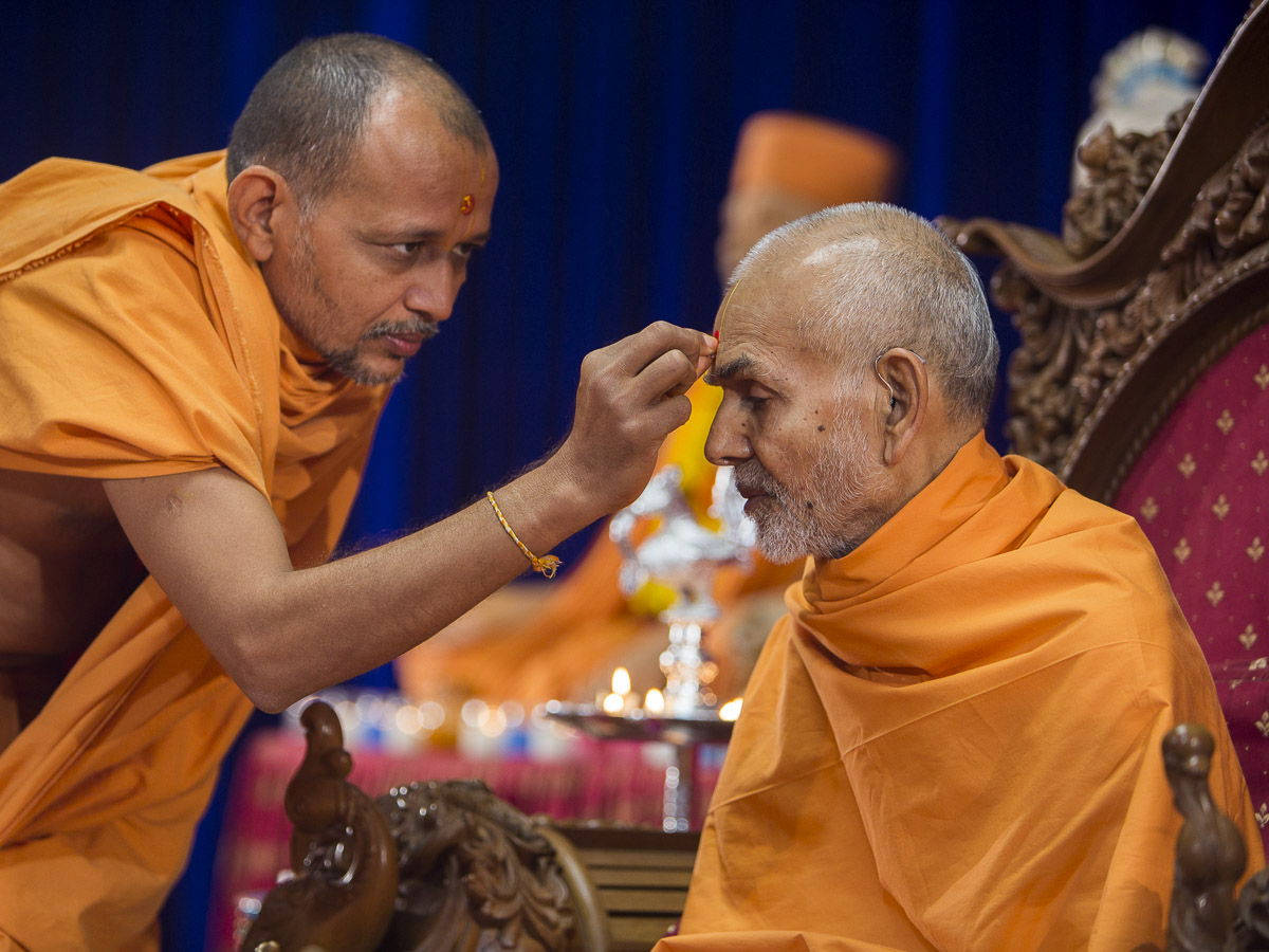 Divyapurush Swami applies chandlo to Param Pujya Mahant Swami