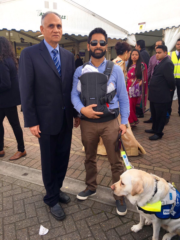 A visitor and his guide dog enjoy the New Year celebrations, assisted by a volunteer