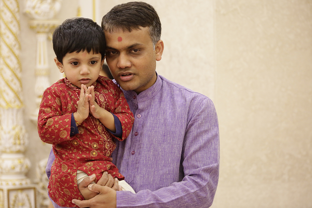 A father and son enjoy darshan