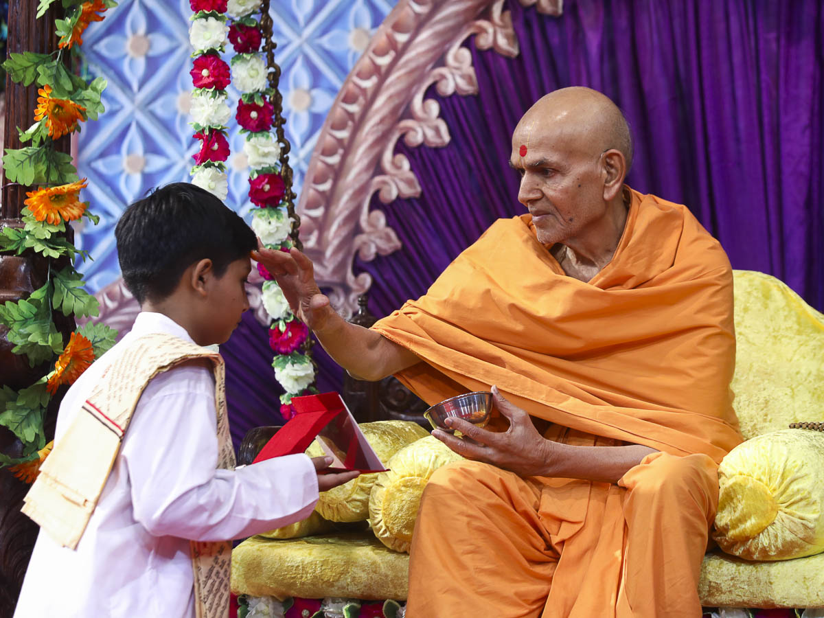 Param Pujya Mahant Swami applies archa to a child, 15 Nov 2016