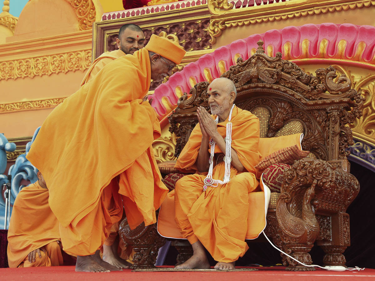 Pujya Doctor Swami honors Param Pujya Mahant Swami with a garland