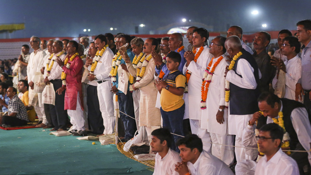 Fathers of the newly initiated sadhus are honored with garlands
