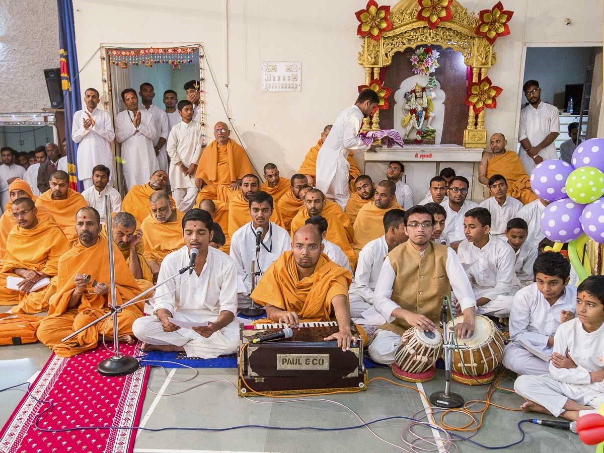 Youths sing kirtans in Param Pujya Mahant Swami Maharaj's puja, 25 Dec 2016