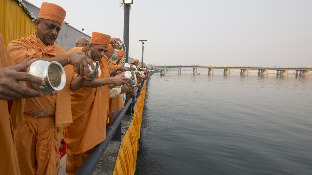 Sadhus perform abhishek of water from 108 holy rivers of India into the River Sabarmati 