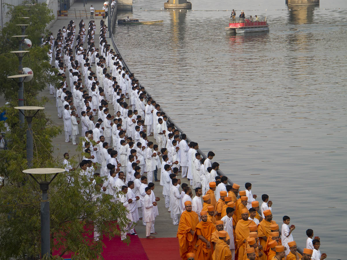 Sadhus and children perform abhishek of water from 108 holy rivers of India into the River Sabarmati 