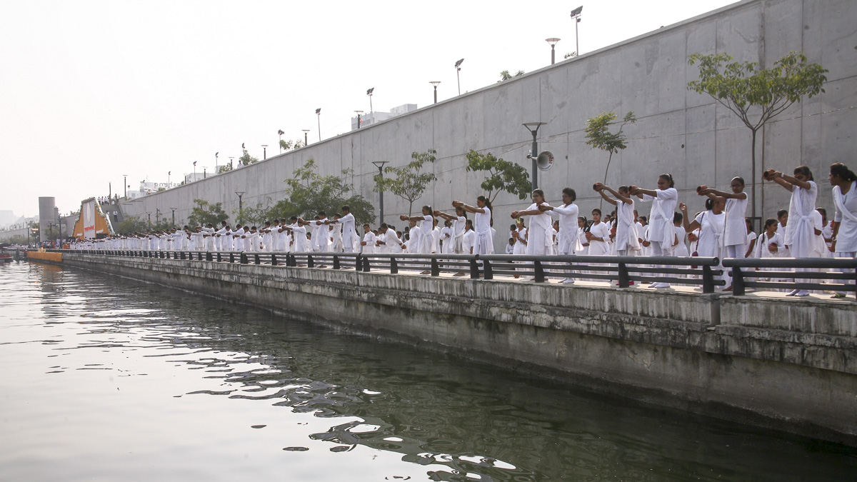 Children perform abhishek of water from 108 holy rivers of India into the River Sabarmati 