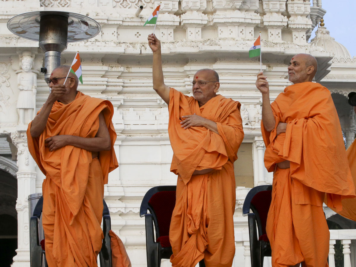 Pujya Bhaktipriya Swami, Pujya Ishwarcharan Swami and Pujya Viveksagar Swami wave Indian flags, 26 Jan 2017