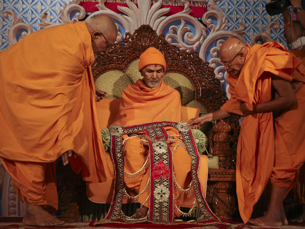 Pujya Kothari Swami and Pujya Tyagvallabh Swami honor Param Pujya Mahant Swami Maharaj with a shawl, 29 Jan 2017