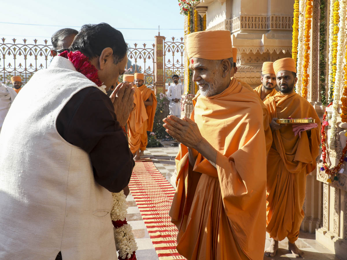 Param Pujya Mahant Swami Maharaj honors the Chief Minister of Gujarat Shri Vijaybhai Rupani with a garland