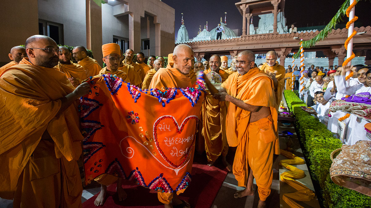 Sadhus honor Param Pujya Mahant Swami Maharaj with a shawl, 20 Feb 2017