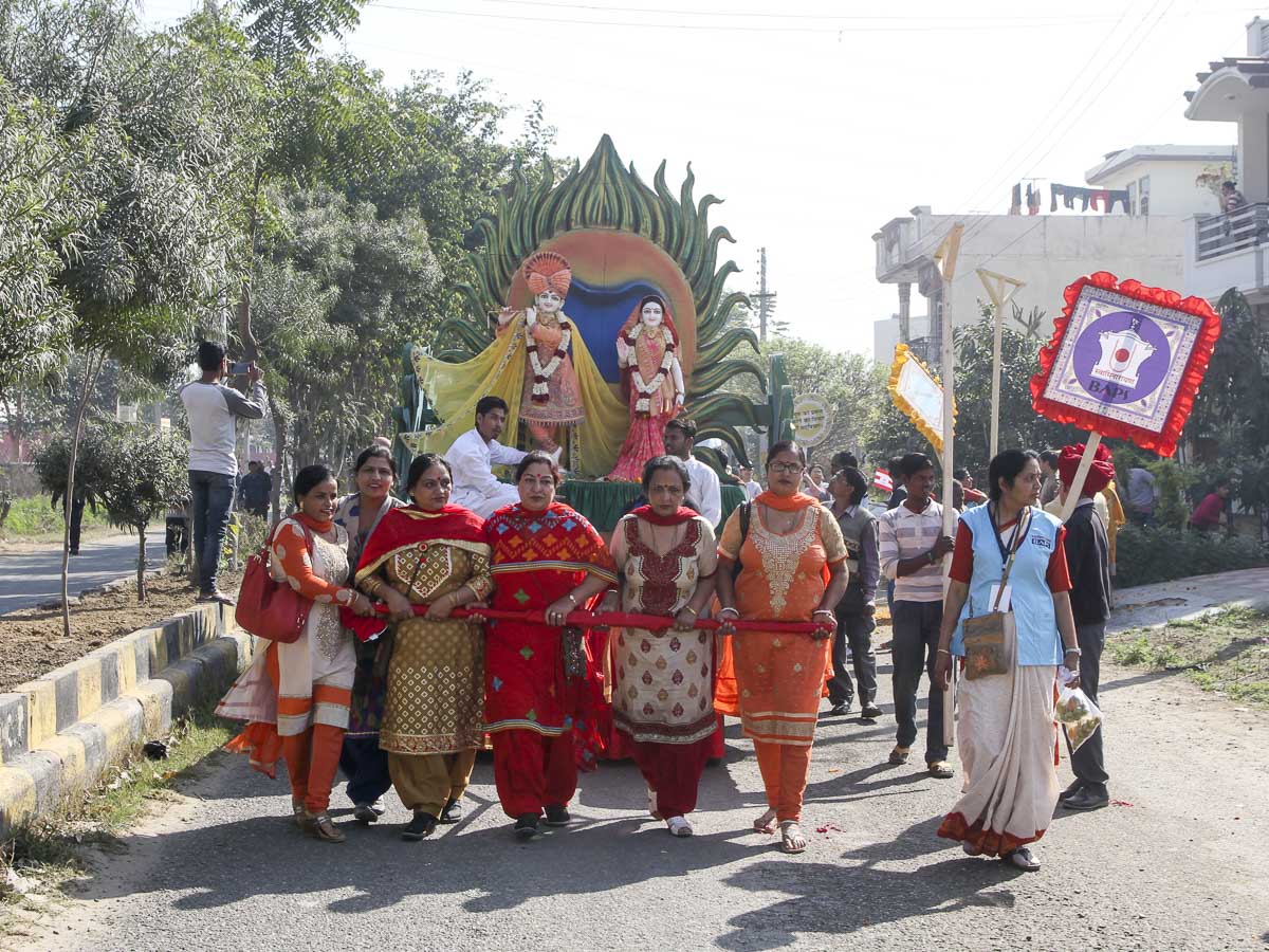 Women devotees pull the murtis of Shri Radha-Krishna Dev in a decorated chariot