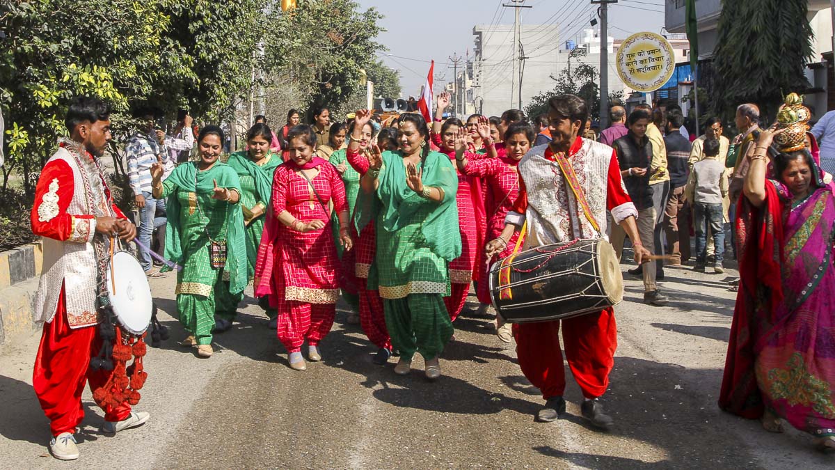 Women devotees in traditional dresses participate in the procession