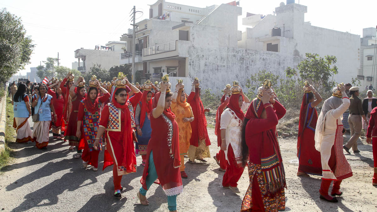 Women devotees carry kalashes and coconuts in traditional style during the procession