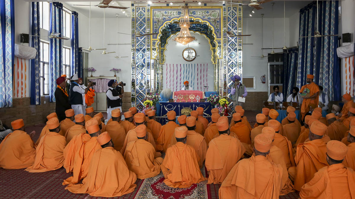 Pujya Ishwarcharan Swami and sadhus visit a gurudwara on the procession route for darshan