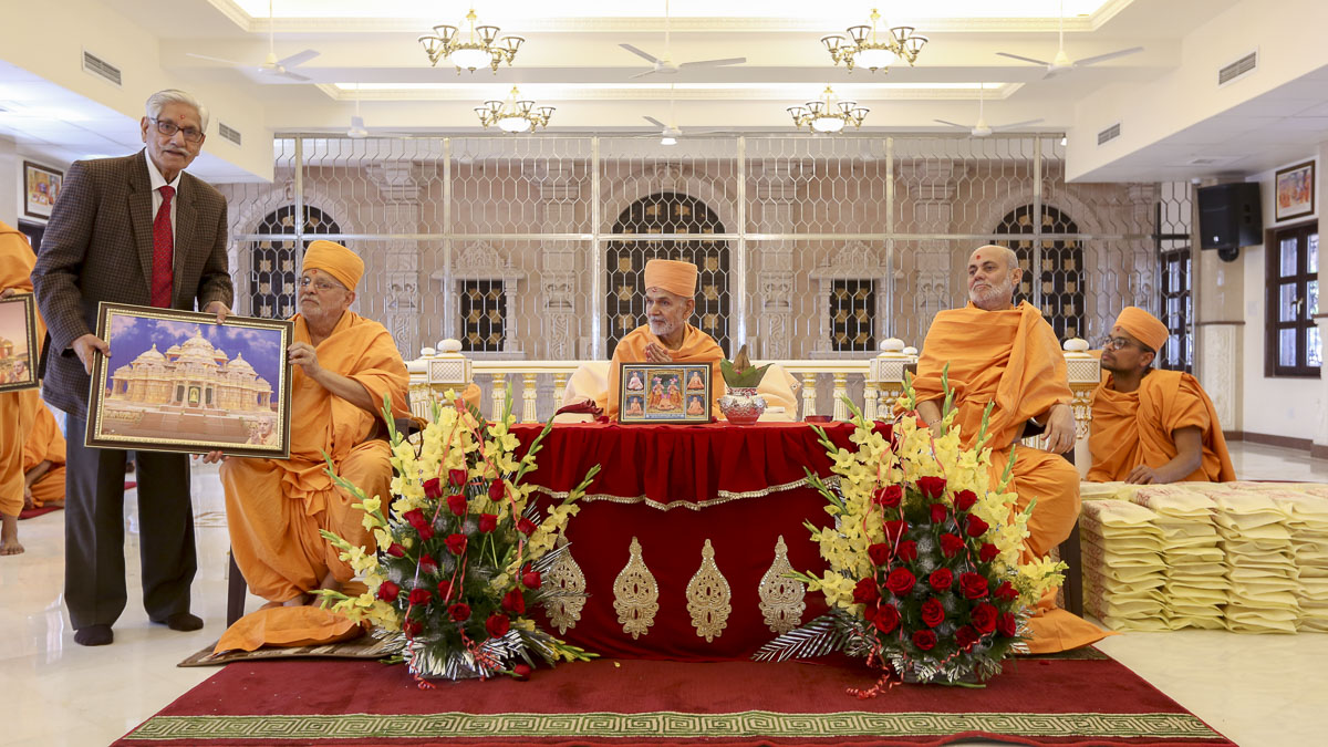 Pujya Ishwarcharan Swami presents a memento to a devotee