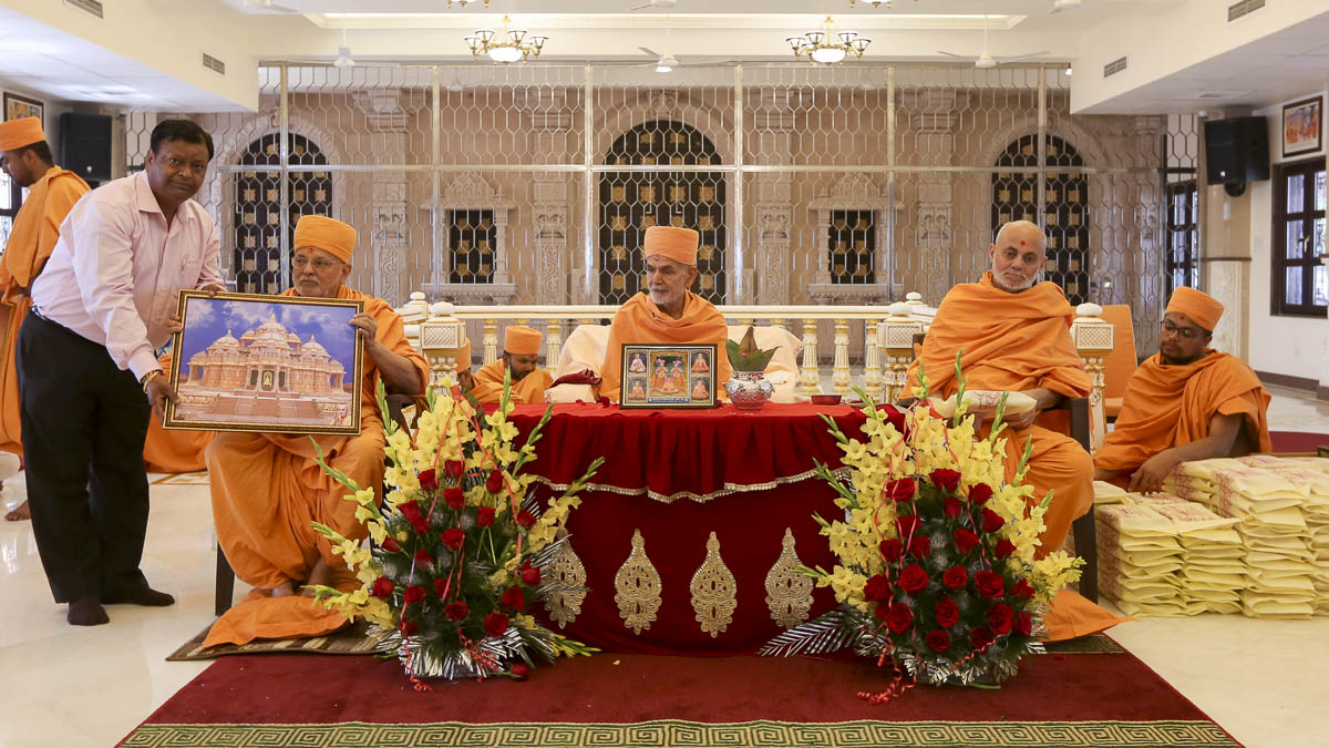 Pujya Ishwarcharan Swami presents a memento to a devotee