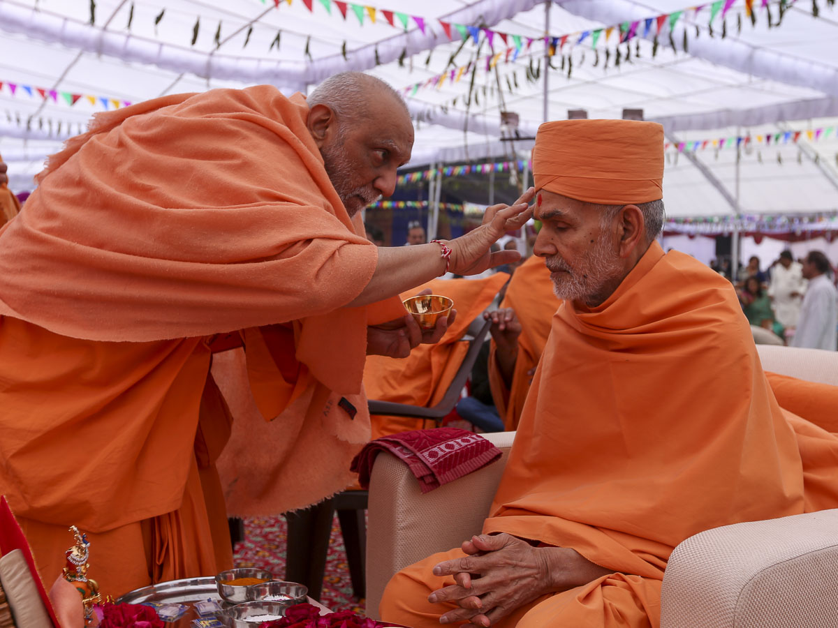 Atmaswarup Swami applies chandlo to Param Pujya Mahant Swami Maharaj