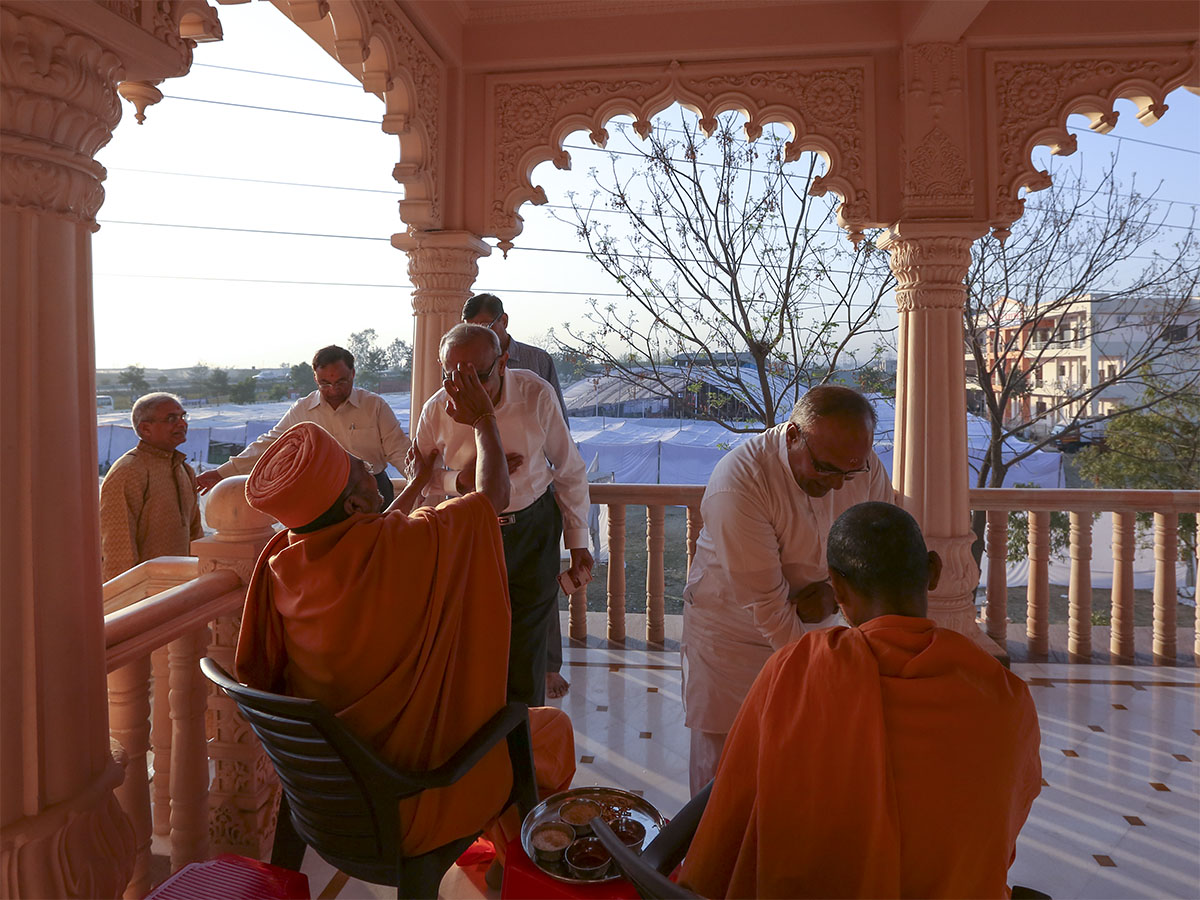 Sadhus apply chandlo and tie nadachhadi to devotees