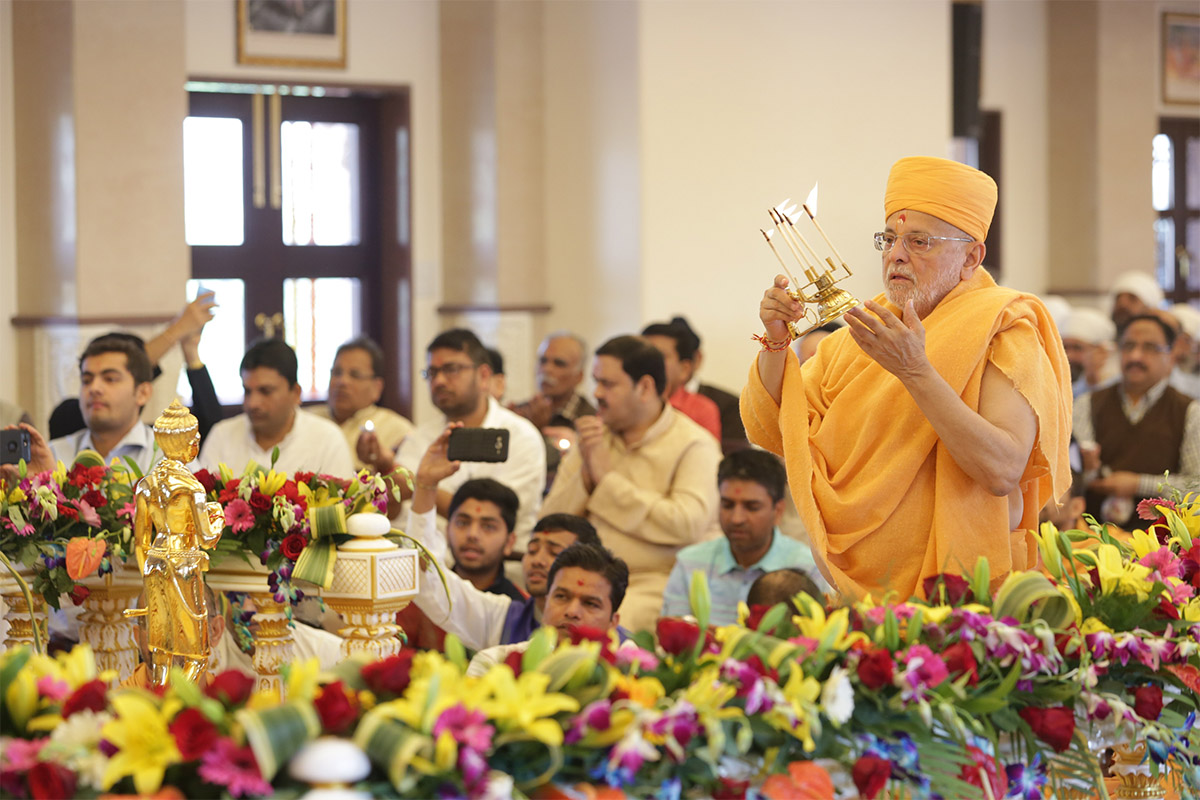 Pujya Ishwarcharan Swami performs the murti-pratishtha arti