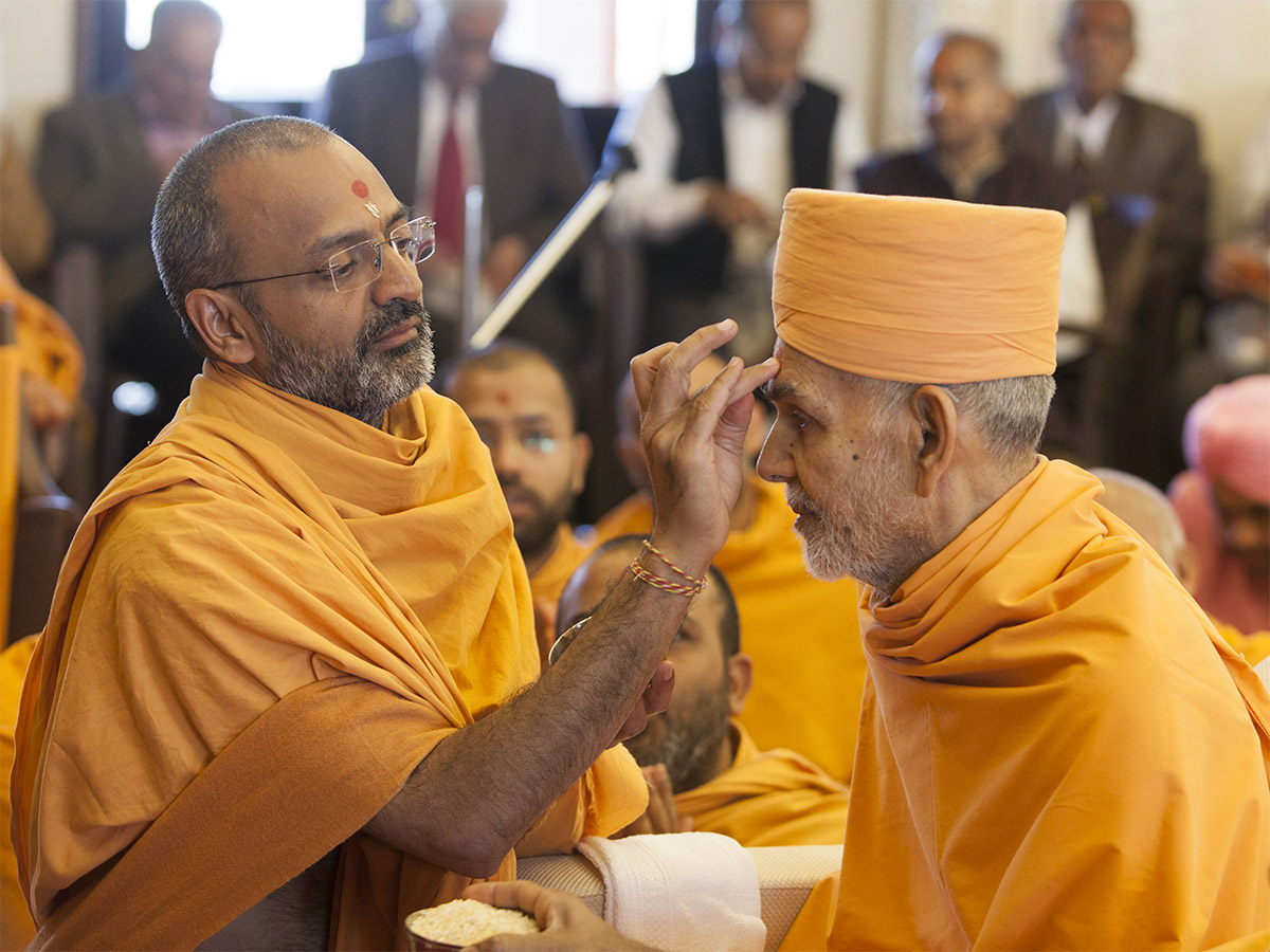 Munivatsal Swami applies chandlo to Param Pujya Mahant Swami Maharaj