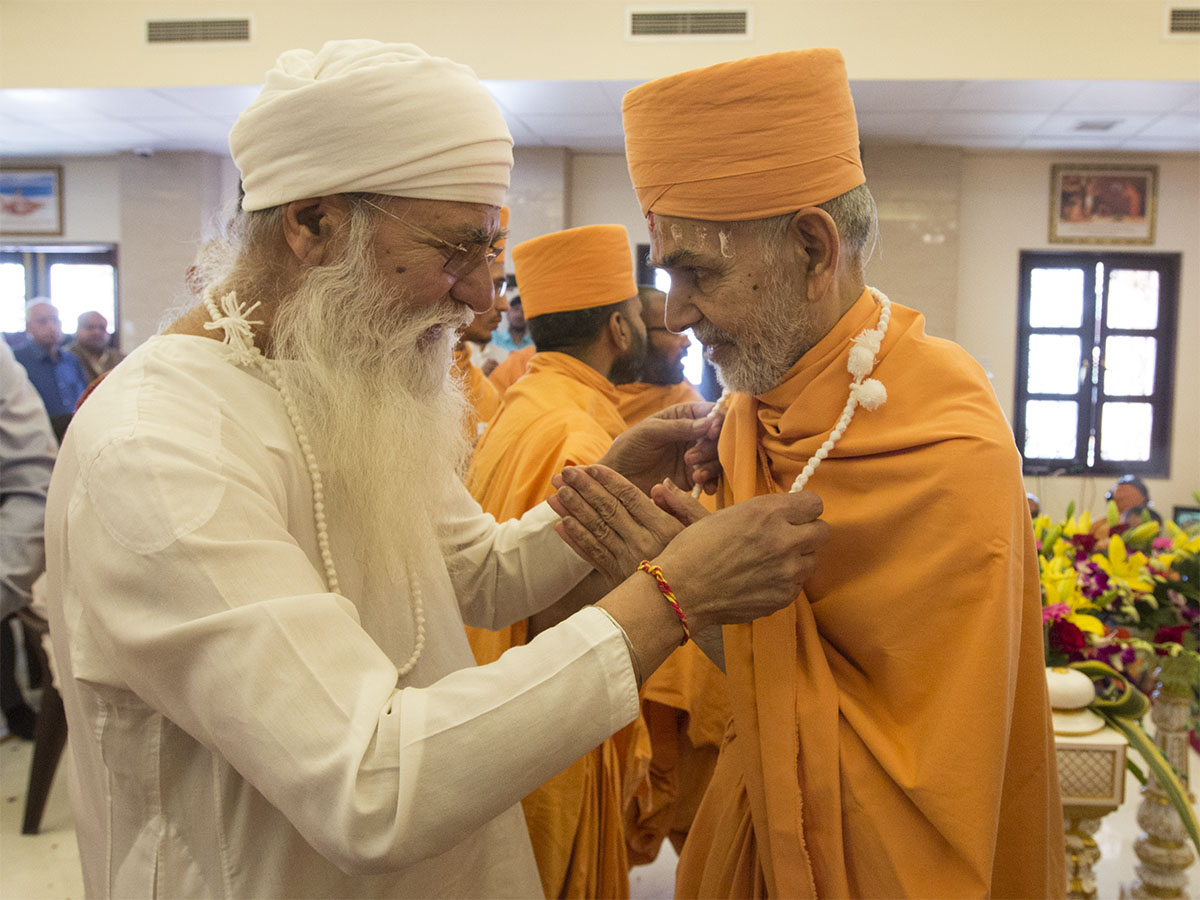 A well-wisher honors Param Pujya Mahant Swami Maharaj 