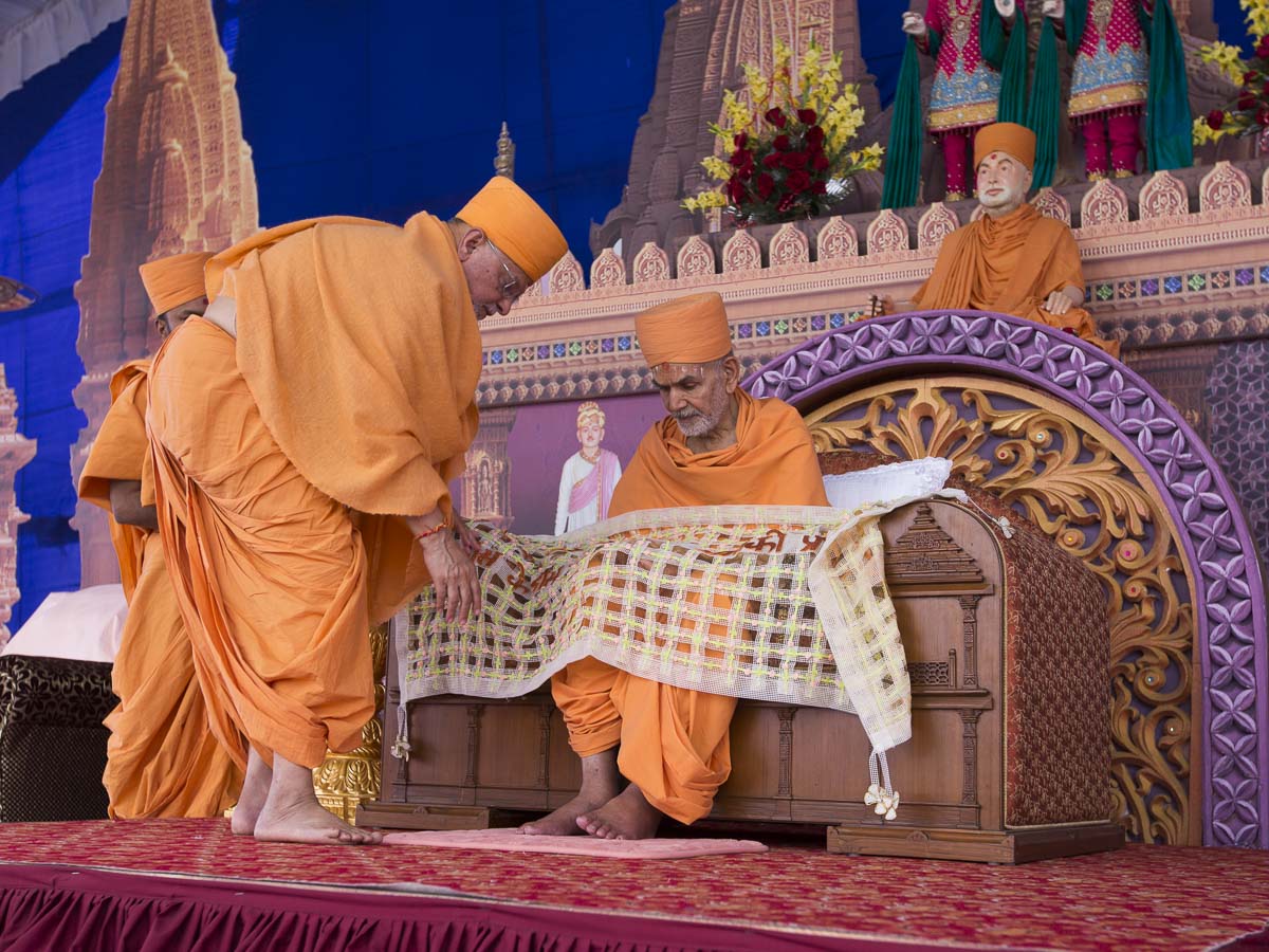 Pujya Ishwarcharan Swami honors Param Pujya Mahant Swami Maharaj with a shawl