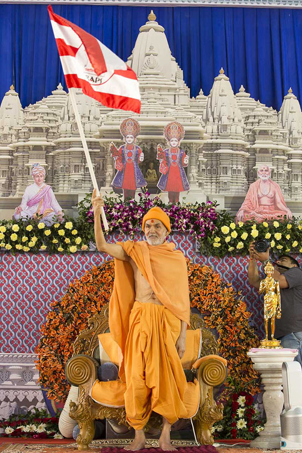 Param Pujya Mahant Swami Maharaj waves a BAPS flag, 6 Mar 2017