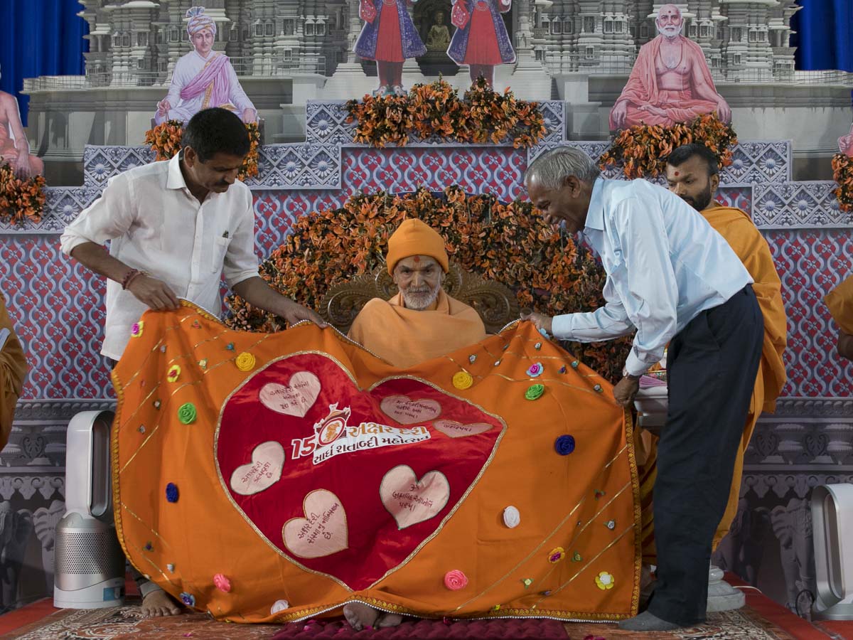 Harshadbhai and Prakashbhai honor Param Pujya Mahant Swami Maharaj with a shawl, 7 Mar 2017