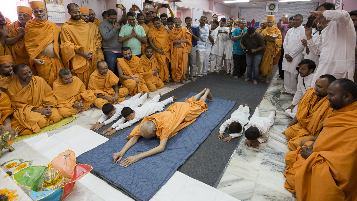 Param Pujya Mahant Swami Maharaj and students perform dandavats to Thakorji, 7 Mar 2017