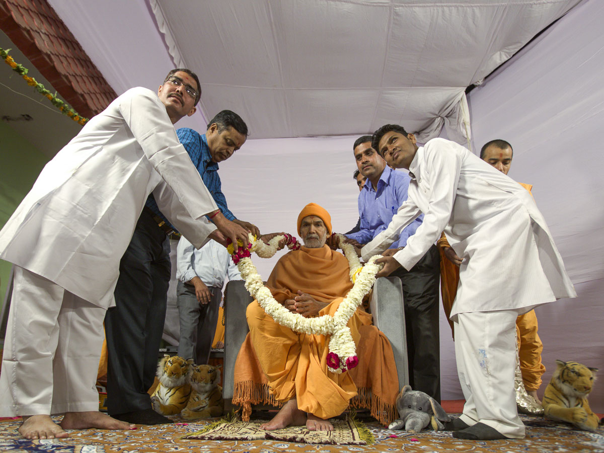 Teachers honor Param Pujya Mahant Swami Maharaj with a garland, 7 Mar 2017