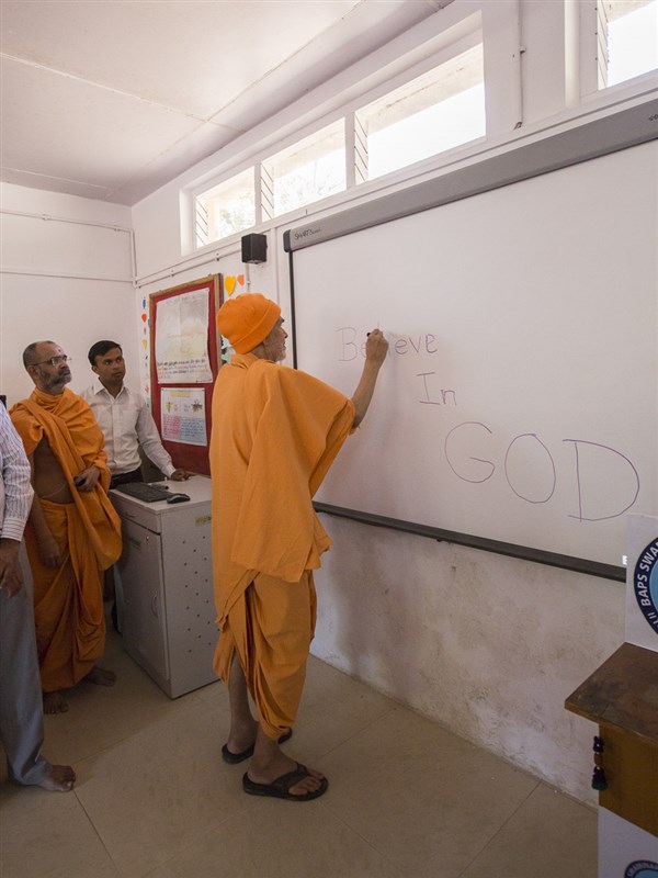Param Pujya Mahant Swami Maharaj writes message on a board, 8 Mar 2017
