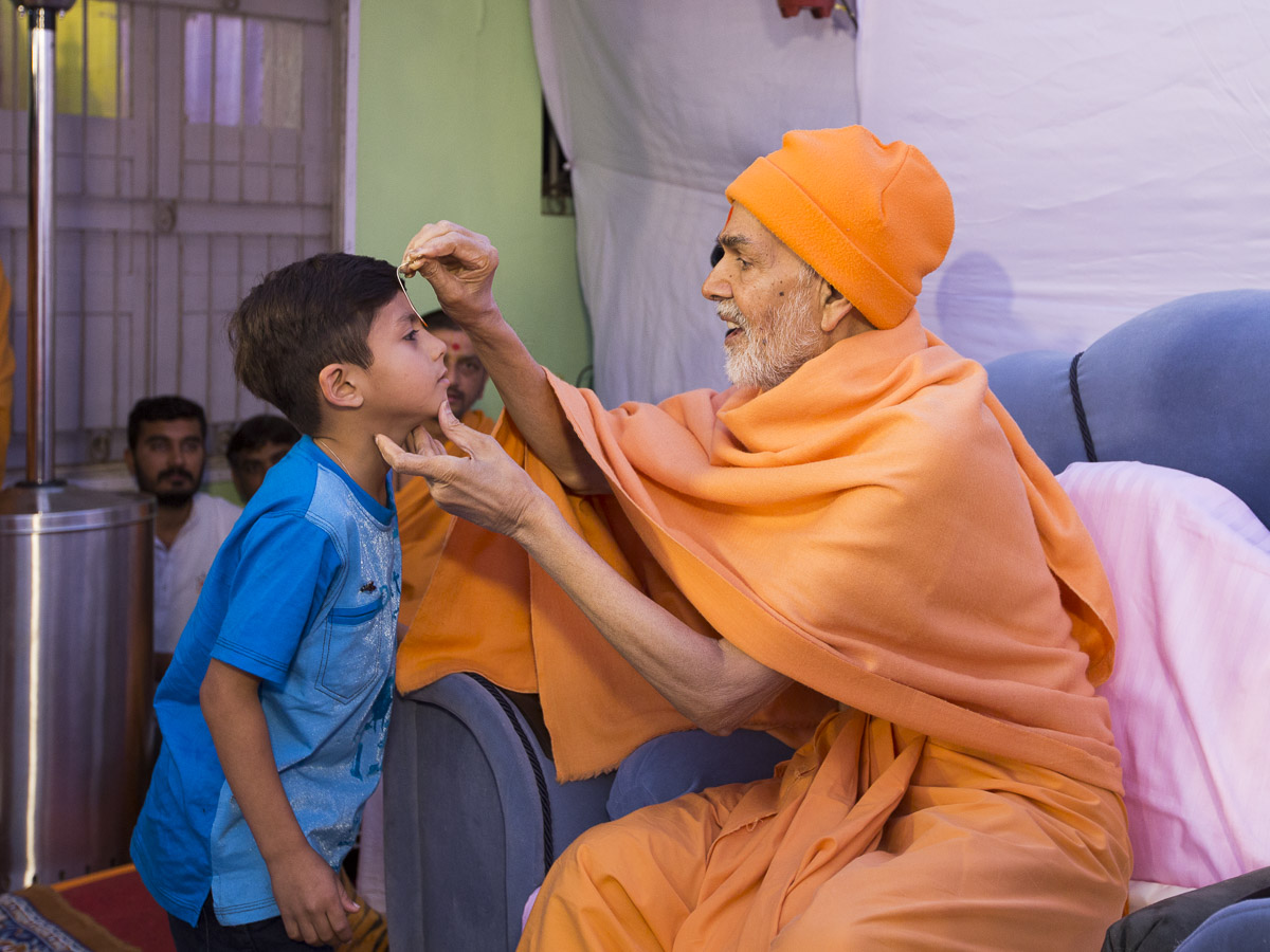 Param Pujya Mahant Swami Maharaj applies tilak-chandlo to a student, 9 Mar 2017