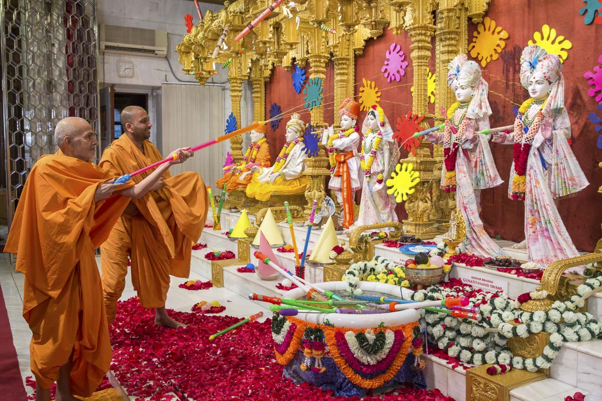 Param Pujya Mahant Swami Maharaj sprays saffron-scented water on Bhagwan Swaminarayan and Aksharbrahma Gunatitanand Swami, 19 Mar 2017