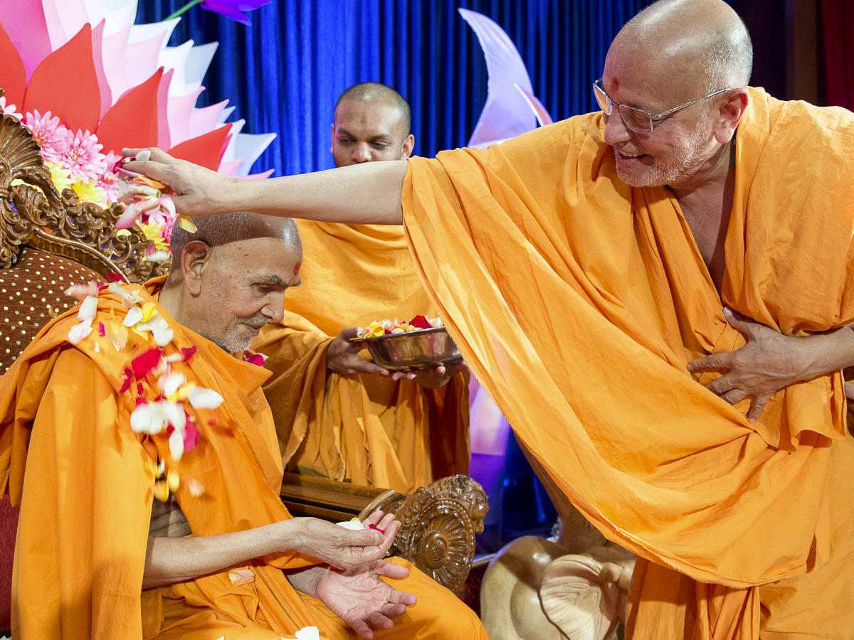 Pujya Ishwarcharan Swami showers flower petals on Param Pujya Mahant Swami Maharaj, 19 Mar 2017