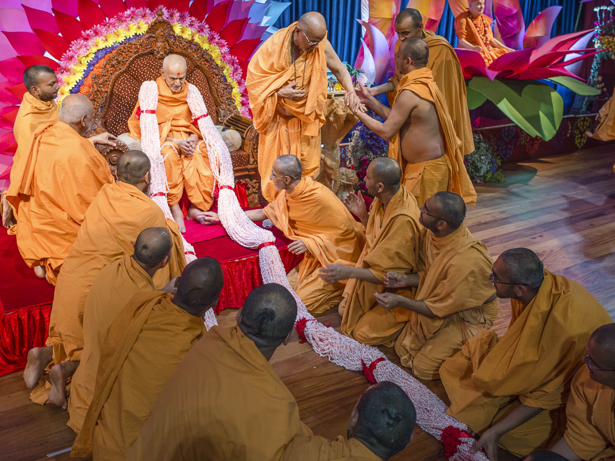 Sadhus honor Param Pujya Mahant Swami Maharaj with a garland, 18 Mar 2017