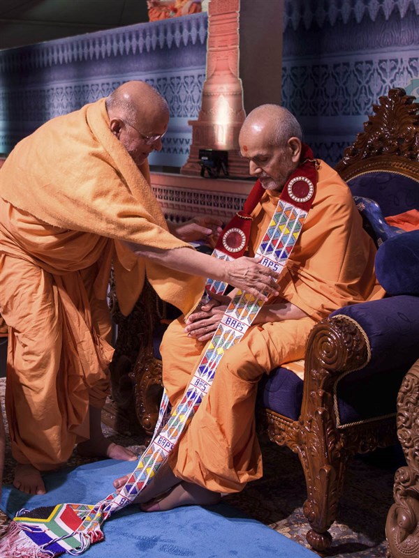 Pujya Ishwarcharan Swami honors Param Pujya Mahant Swami Maharaj with a garland, 24 Mar 2017