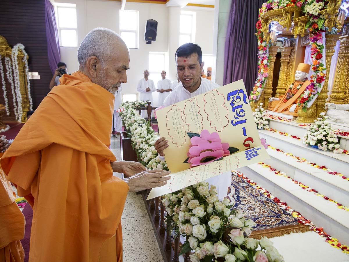Swamishri sanctifies a card, 5 Apr 2017