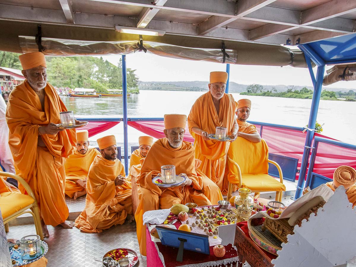 Param Pujya Mahant Swami Maharaj, Pujya Ishwarcharan Swami and Atmaswarup Swami perform arti