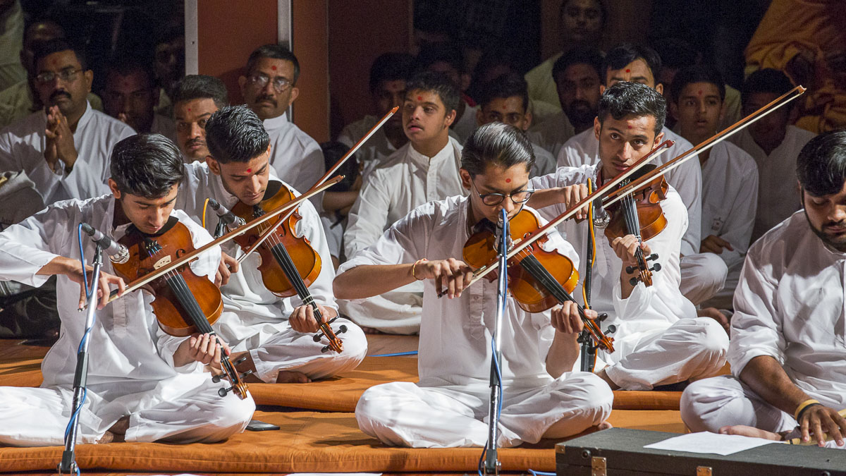 Youths play violins in Swamishri's morning puja, 14 Apr 2017