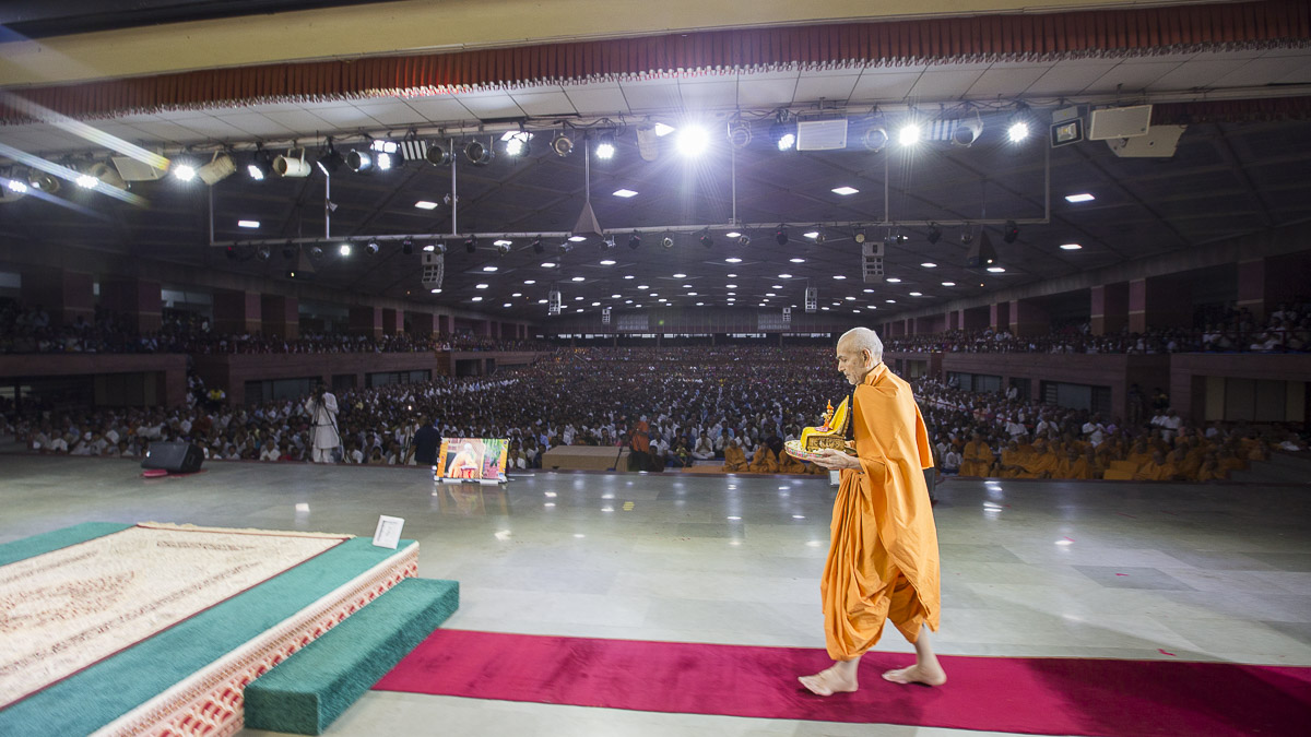 Swamishri arrives in the Sunday satsang assembly with Shri Harikrishna Maharaj, 16 Apr 2017