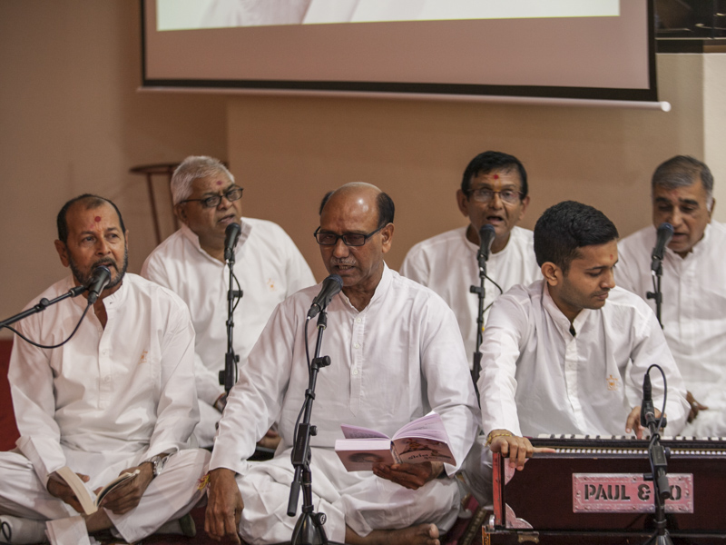 Devotees sing kirtans in the shibir