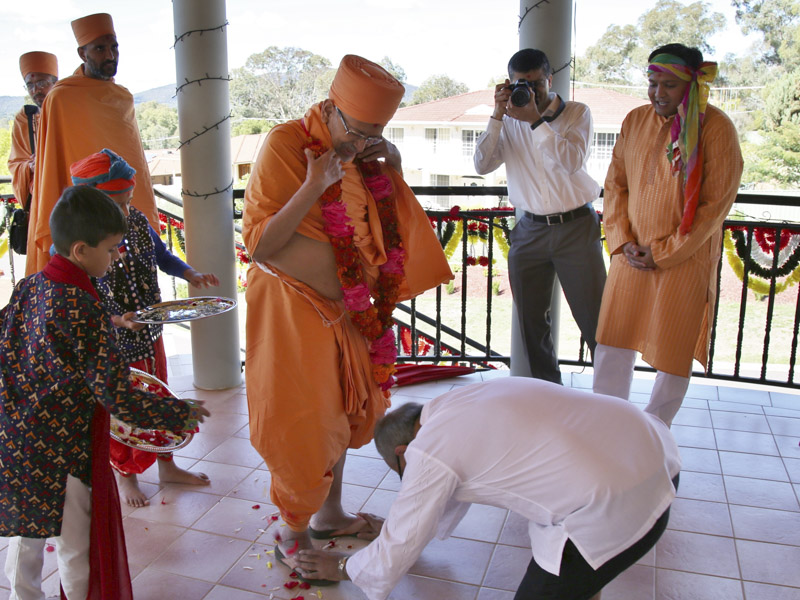 A devotee honors Pujya Tyagvallabh Swami with a garland