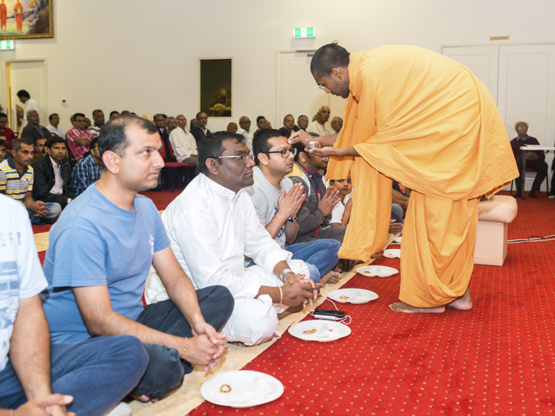 Vedantpriya Swami applies chandlo to devotees