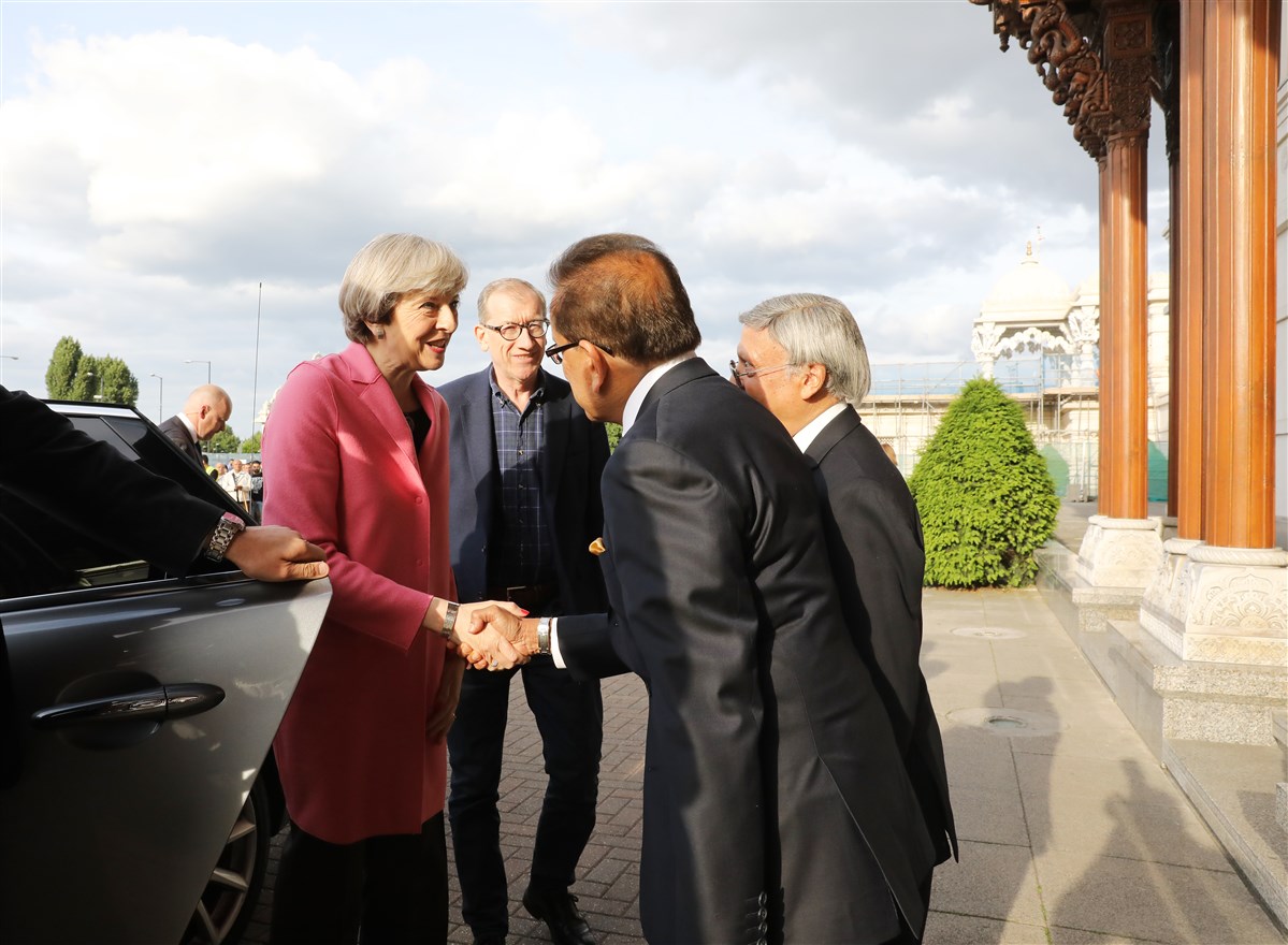 Prime Minister Theresa May is greeted by trustees as she arrives at London Mandir